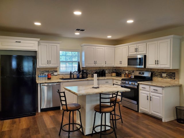 kitchen with stainless steel appliances, sink, and white cabinets