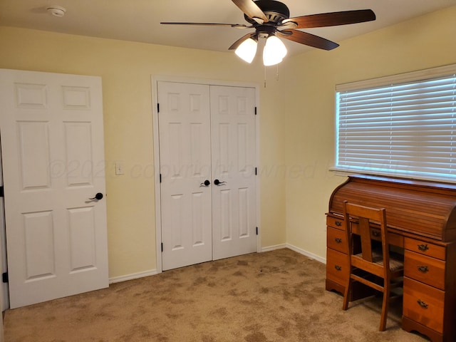 carpeted office space with ceiling fan