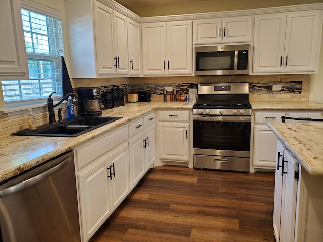 kitchen with appliances with stainless steel finishes, sink, white cabinets, and dark hardwood / wood-style flooring