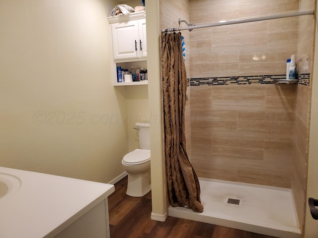 bathroom with hardwood / wood-style flooring, toilet, vanity, and a shower with curtain