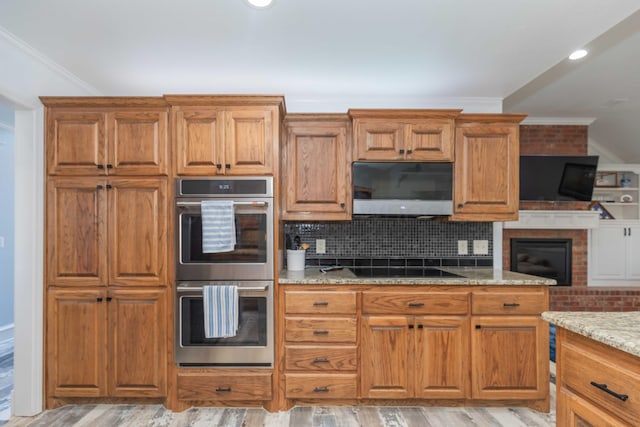 kitchen featuring backsplash, ornamental molding, stainless steel appliances, and light hardwood / wood-style floors