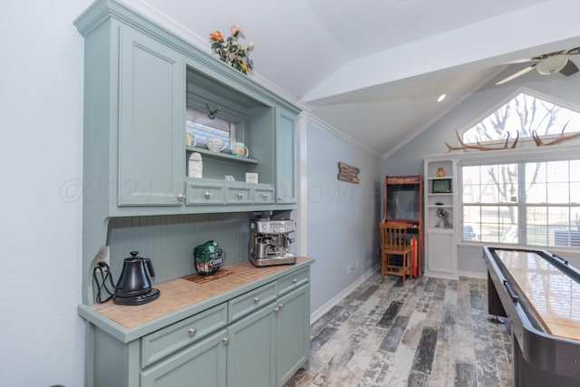 kitchen with light hardwood / wood-style flooring, ceiling fan, and lofted ceiling