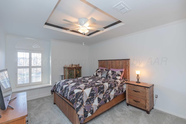 carpeted bedroom featuring a tray ceiling, ceiling fan, and ornamental molding