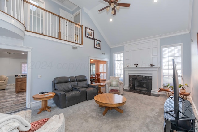 living room featuring high vaulted ceiling, light colored carpet, a premium fireplace, and a wealth of natural light