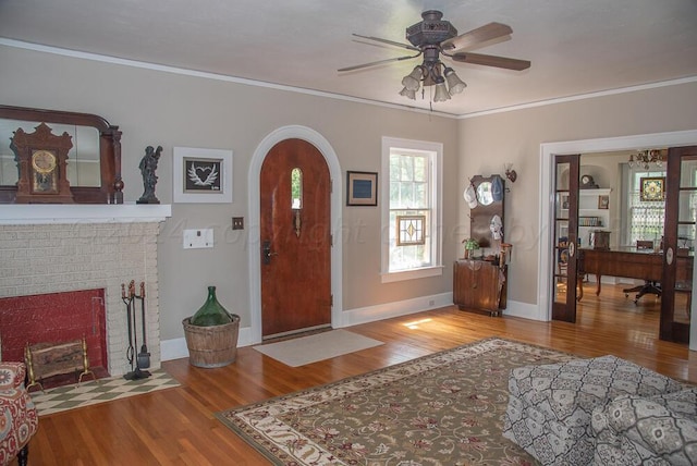 2122 S Hayden St, Amarillo, TX 79109 - foyer featuring ceiling fan, wood finished floors, ornamental molding, arched walkways, and a fireplace