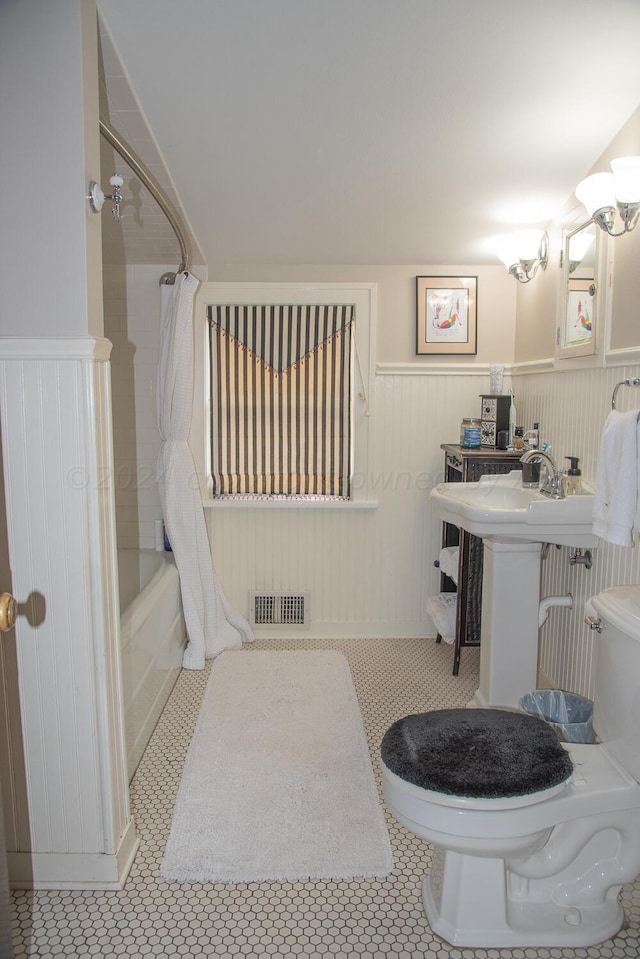 2122 S Hayden St, Amarillo, TX 79109 - bathroom featuring shower / bath combination with curtain and wainscoting