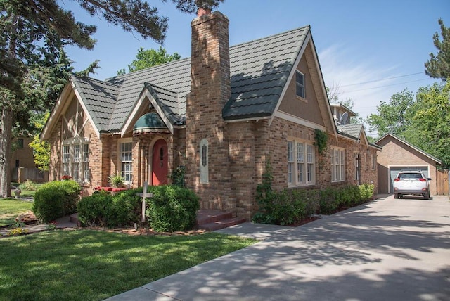 2122 S Hayden St, Amarillo, TX 79109 - tudor home featuring a chimney, driveway, an outbuilding, brick siding, and a front yard