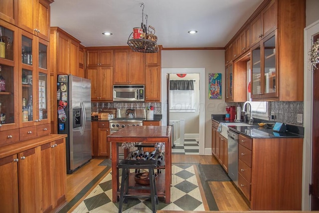 2122 S Hayden St, Amarillo, TX 79109 - kitchen with stainless steel appliances, brown cabinetry, dark countertops, recessed lighting, and backsplash
