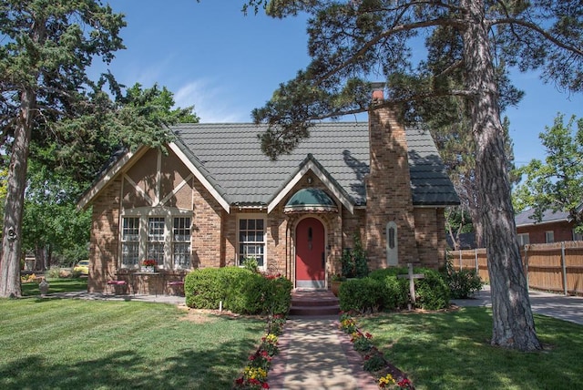 2122 S Hayden St, Amarillo, TX 79109 - english style home featuring a tile roof, a chimney, and brick siding