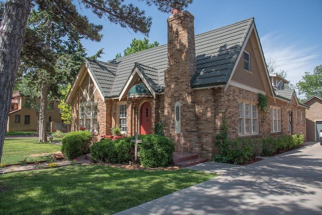 2122 S Hayden St, Amarillo, TX 79109 - tudor home with a chimney, a front yard, and brick siding