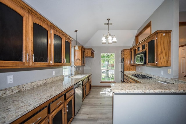 kitchen featuring appliances with stainless steel finishes, sink, light wood-type flooring, decorative light fixtures, and kitchen peninsula