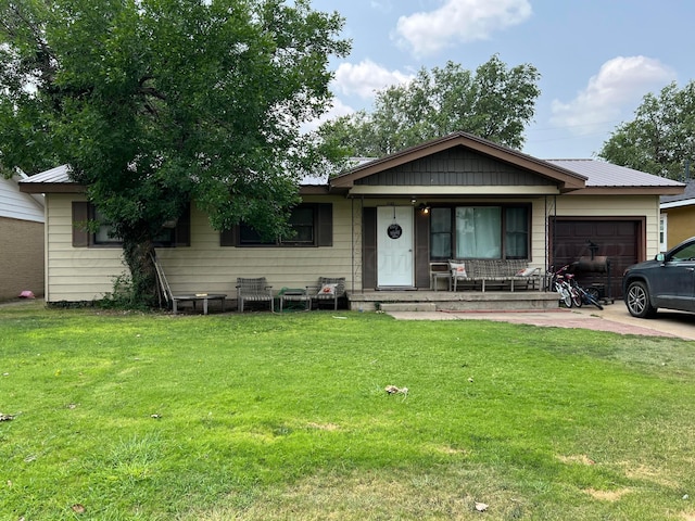 view of front of home featuring covered porch, a garage, and a front lawn