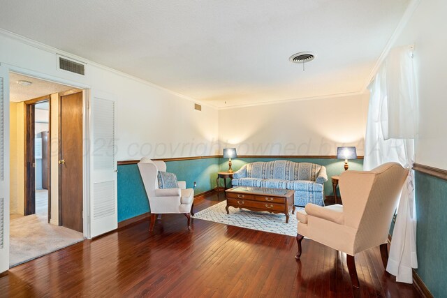 sitting room featuring hardwood / wood-style flooring, crown molding, and baseboards