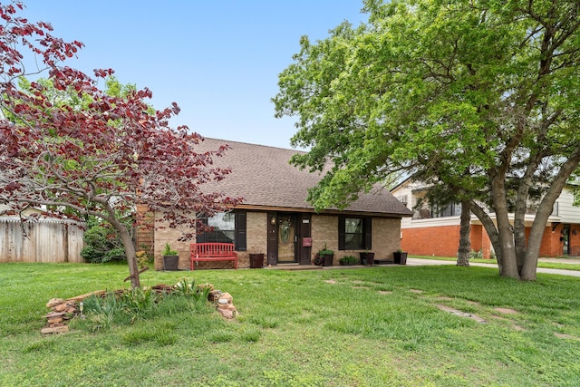 view of front of home featuring roof with shingles and brick siding