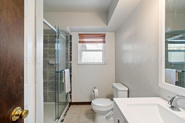 full bath with a stall shower, vanity, tile patterned floors, and toilet