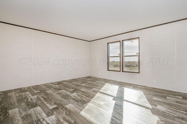 empty room featuring hardwood / wood-style floors and crown molding