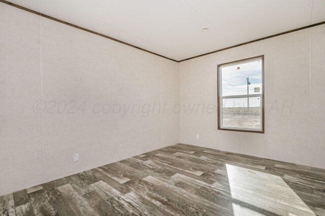 empty room featuring hardwood / wood-style flooring and crown molding