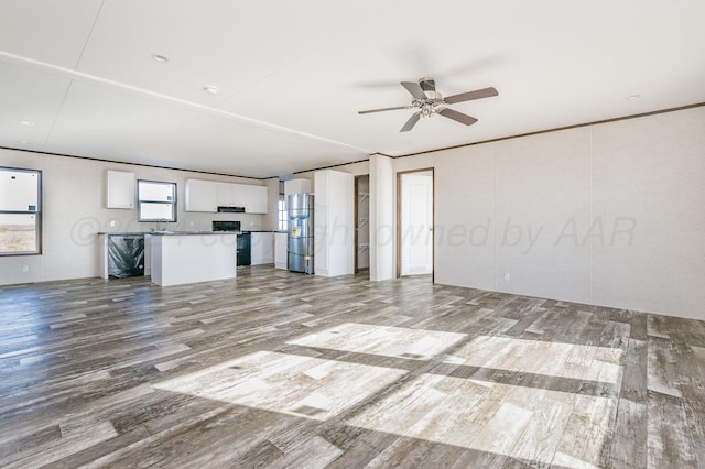 unfurnished living room featuring ceiling fan and light hardwood / wood-style floors