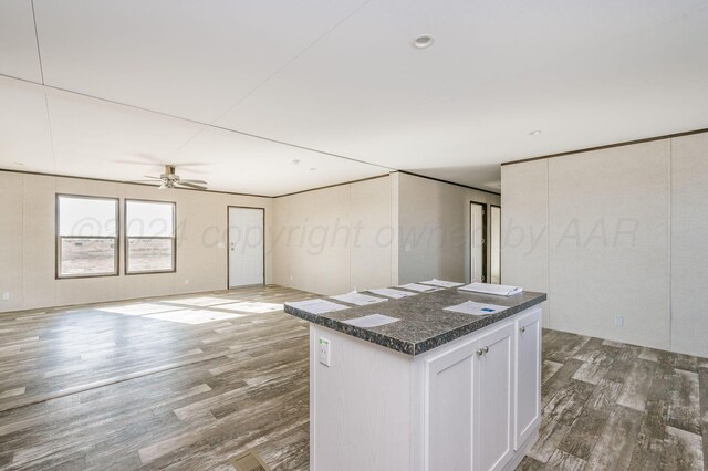 kitchen with white cabinets, a center island, dark hardwood / wood-style floors, and ceiling fan