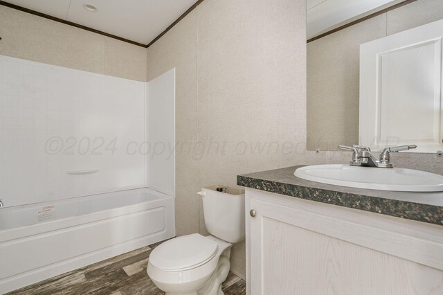 full bathroom featuring hardwood / wood-style floors, vanity, bathing tub / shower combination, crown molding, and toilet