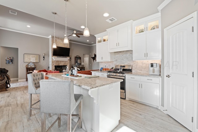 6702 Tatum Cir, Amarillo, TX 79119 - kitchen with gas range, ceiling fan, crown molding, open floor plan, and tasteful backsplash
