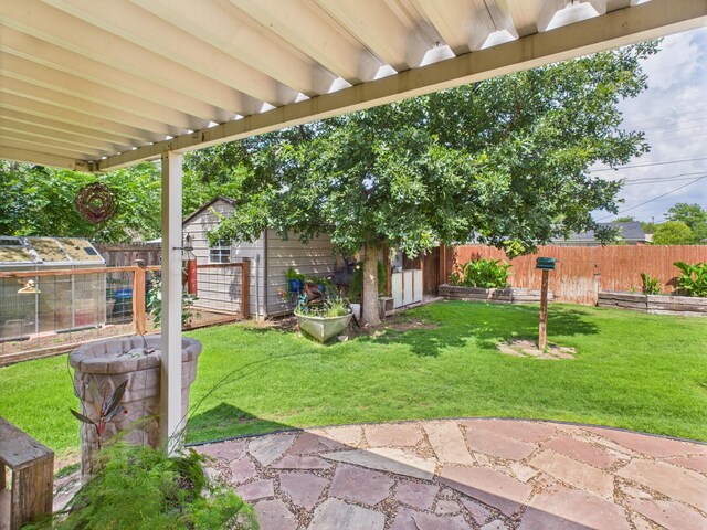 317 Morton Ave, Dumas, TX 79029 - fenced backyard featuring an outbuilding, a patio area, and a greenhouse