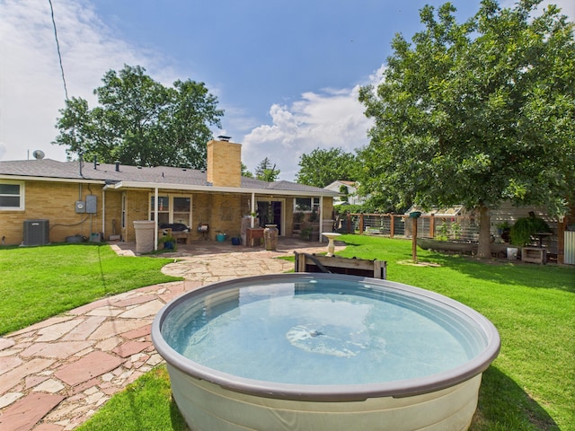 317 Morton Ave, Dumas, TX 79029 - view of swimming pool featuring a hot tub, a patio area, and a yard