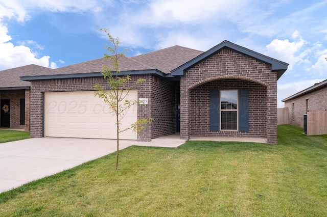 ranch-style home featuring brick siding, a front yard, driveway, an attached garage, and roof with shingles