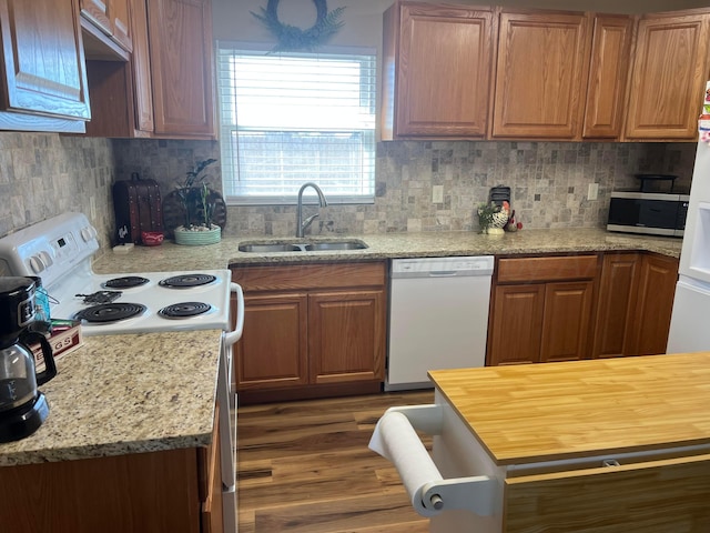 kitchen with white appliances, dark wood-style floors, tasteful backsplash, and a sink