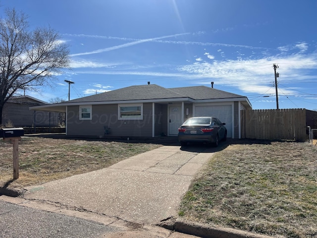 single story home with driveway, an attached garage, and fence