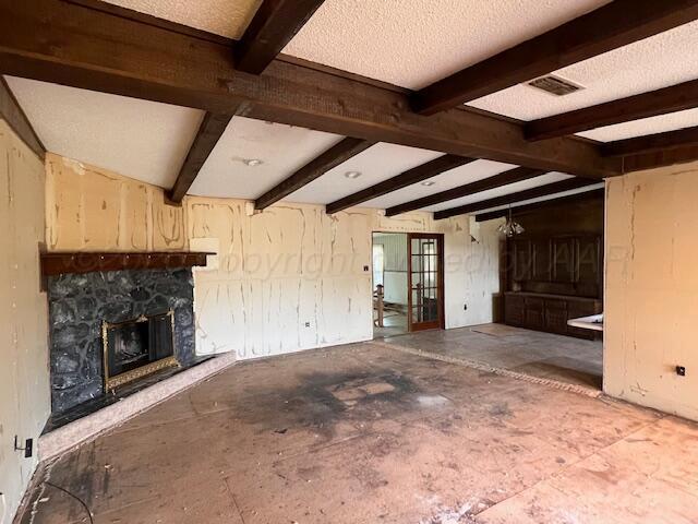 3102 S Main St, Perryton, TX 79070 - unfurnished living room with a fireplace, beam ceiling, and french doors