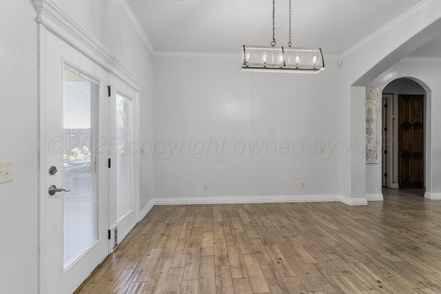8121 Alexandria Ave, Amarillo, TX 79118 - unfurnished dining area with arched walkways, ornamental molding, light wood-style flooring, and baseboards