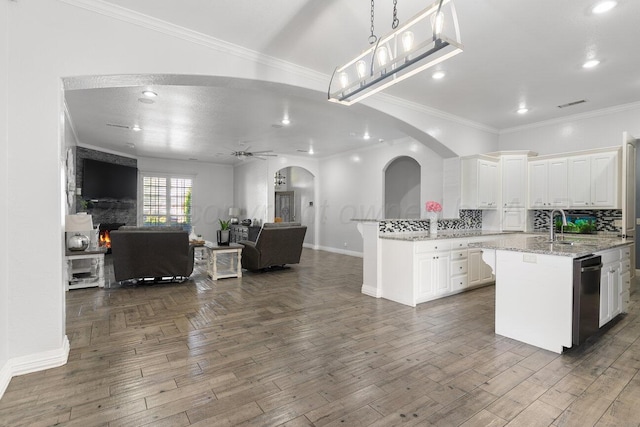 8121 Alexandria Ave, Amarillo, TX 79118 - kitchen with open floor plan, white cabinets, baseboards, crown molding, and arched walkways