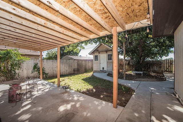 view of patio / terrace with a shed, a fenced backyard, and an outbuilding