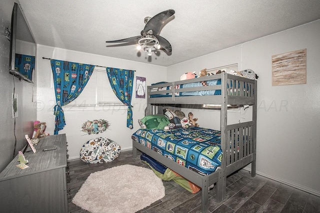 bedroom with dark wood-style floors, baseboards, a ceiling fan, and a textured ceiling