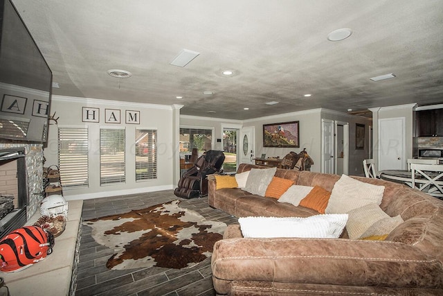 living room featuring baseboards, visible vents, crown molding, a fireplace, and recessed lighting