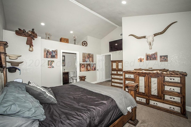 carpeted bedroom featuring ensuite bath and high vaulted ceiling