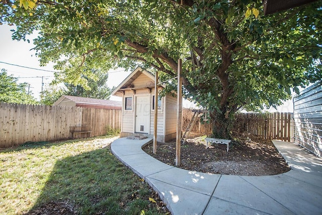 view of yard with a storage unit, an outdoor structure, and a fenced backyard