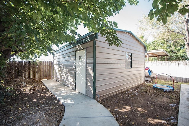 view of outbuilding with fence and an outdoor structure