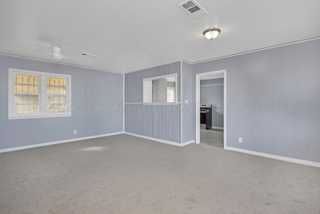 empty room with carpet flooring, a wealth of natural light, and ceiling fan