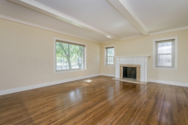 unfurnished living room featuring dark hardwood / wood-style flooring, beamed ceiling, crown molding, and a fireplace