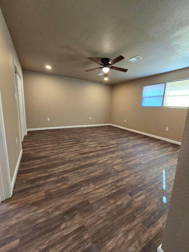 unfurnished room featuring dark hardwood / wood-style floors, a textured ceiling, and ceiling fan