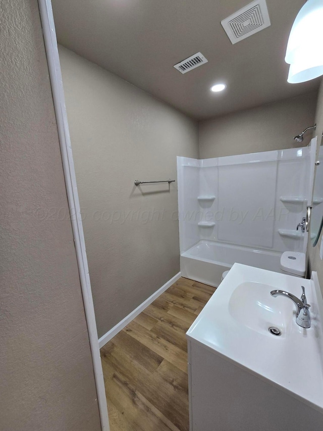 bathroom featuring shower / bathing tub combination, vanity, and hardwood / wood-style flooring