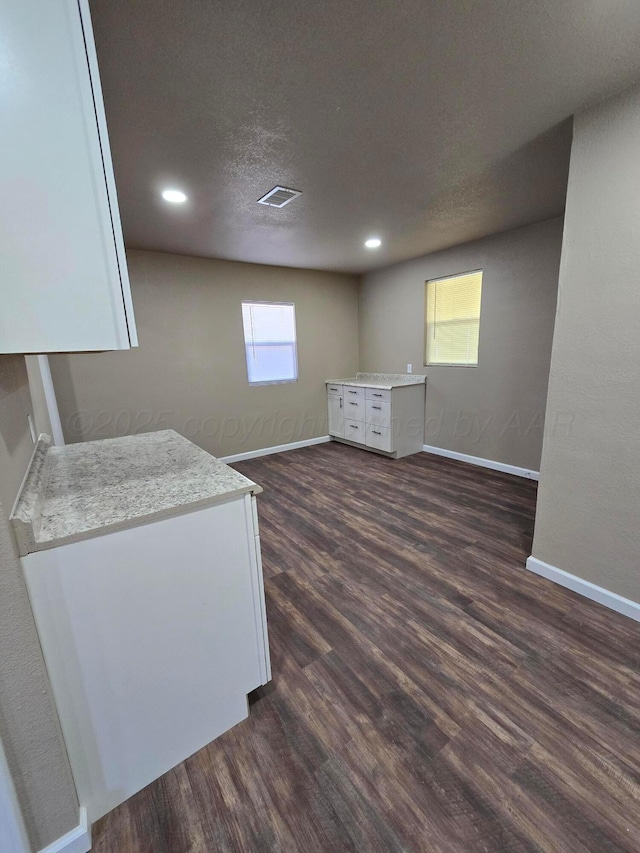 interior space with dark wood-type flooring and a textured ceiling