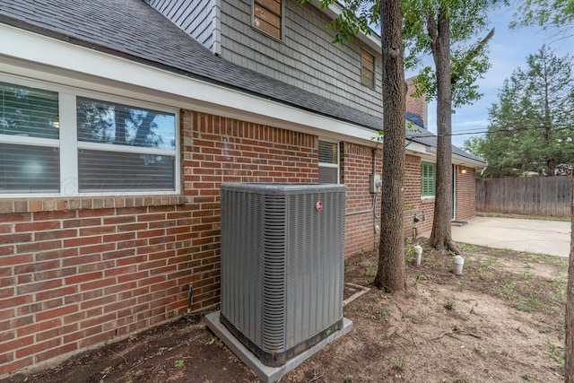 3408 Hawthorne Dr, Amarillo, TX 79109 - exterior view of cooling unit, brick siding, fence, and a shingled roof