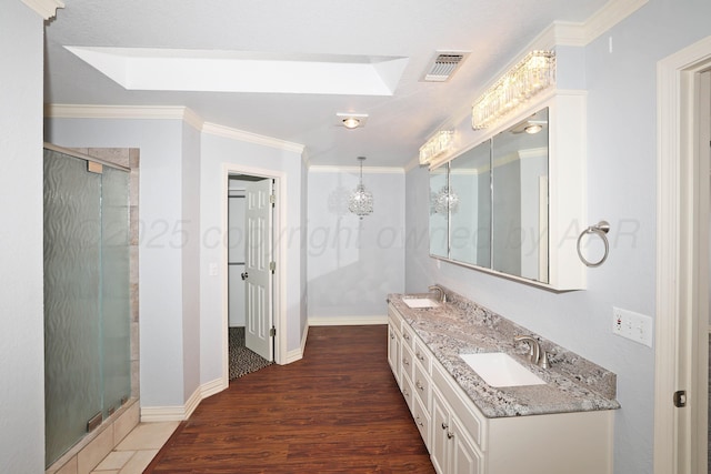 7501 Countryside Dr, Amarillo, TX 79119 - full bath featuring a skylight, a stall shower, double vanity, wood finished floors, and ornamental molding