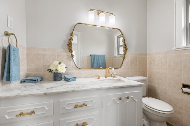 bathroom with vanity, tile walls, and toilet