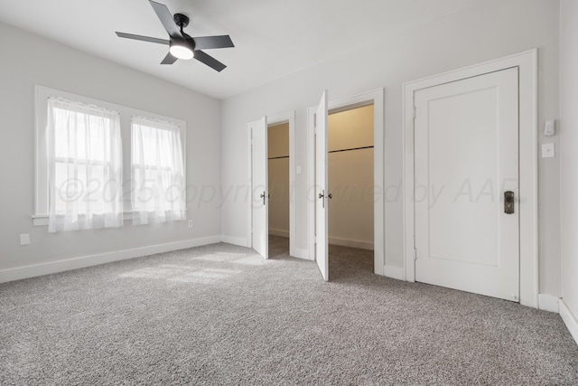 unfurnished bedroom featuring a spacious closet, ceiling fan, and carpet flooring