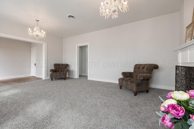 sitting room with a chandelier and carpet