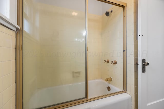 bathroom with bath / shower combo with glass door